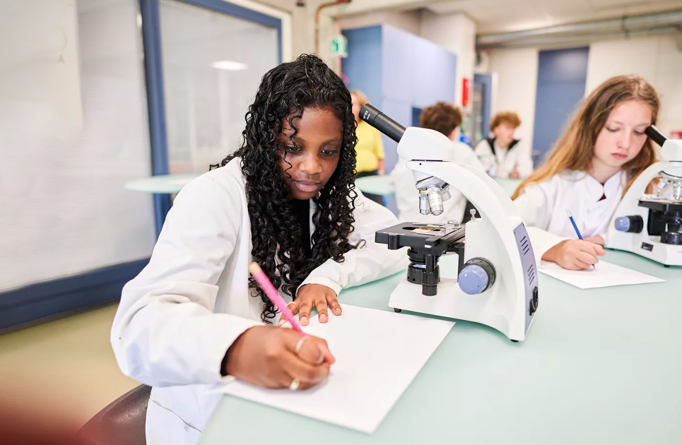 Leerlingen leren met microscopen.