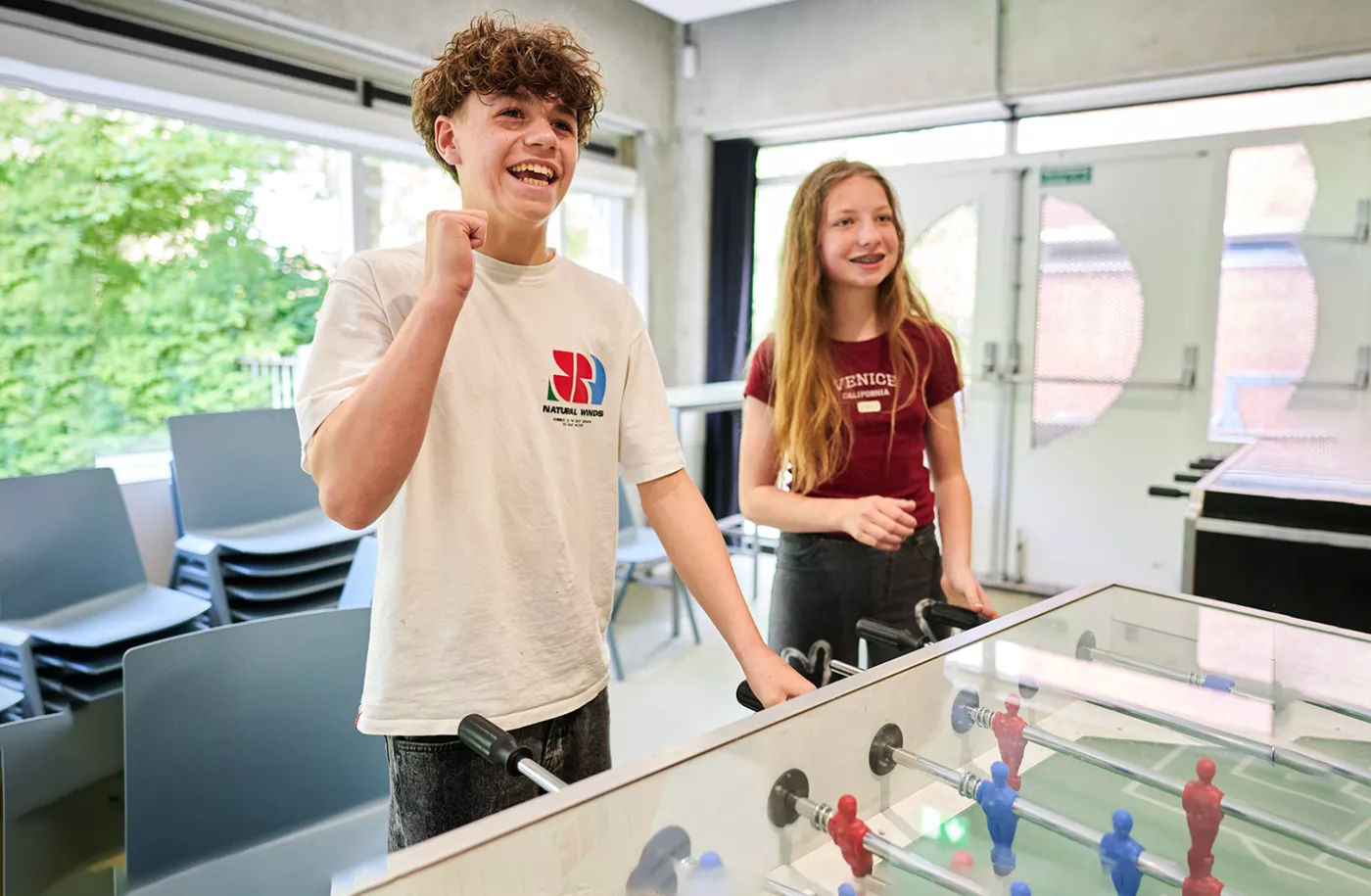 Leerlingen spelen tafelvoetbal.