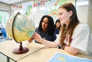 Leerlingen leren met wereldbol.