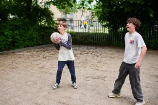 Leerlingen van het Kamerlingh Onnes basketballen op het schoolplein.